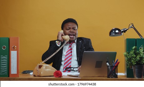 Furious Angry Black Businessman Boss Shouting And Arguing On Telephone Call Conversation Yelling At Employee Working At Desk In Company Office. Bad Day.