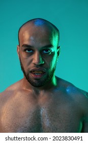 Furious, Angry. One Young Man, Boxer With Mouthguard Isolated On Blue Green Background In Neon Light. Close-up Portrait. Healthy Lifestyle, Sport And Motion Concept.