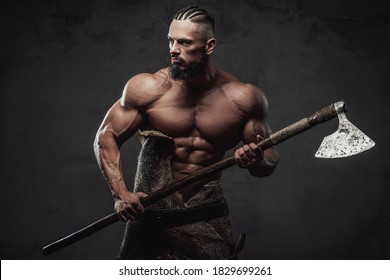 Zorniger und bärtiger Wikingerkrieger mit nacktem Torso und riesigen Schlägen, die bereit sind, seine Waffe im dunklen Hintergrund zu halten.