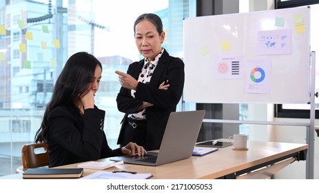 Furious boss scolding young frustrated intern with bad work results. Emotional pressure, stress at work, verbal warning about work failure - Shutterstock ID 2171005053
