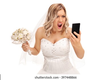 Furious young bride looking at her cell phone and screaming isolated on white background