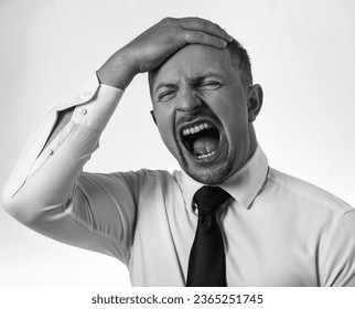 Furious,enraged man with grumpy grimace on his face,with mouth opened in shout - Shutterstock ID 2365251745