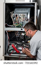 Furnace Repair With A Voltage Meter Used By A Man