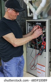 Furnace Repairman Servicing High Efficiency Heating Unit