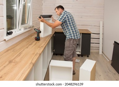 A Furniture Assembler Assembles Modern Kitchen Furniture In A Private Home