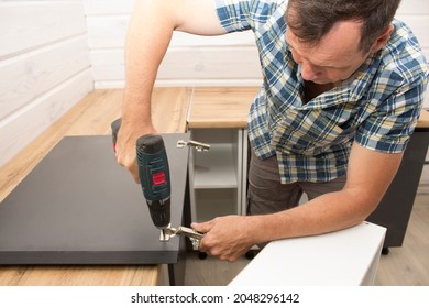 A Furniture Assembler Assembles Modern Kitchen Furniture In A Private Home