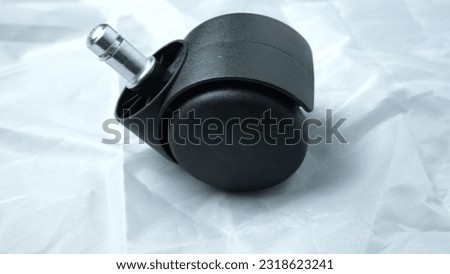 A furniture castor wheel for office chair on white background. Close-up view
