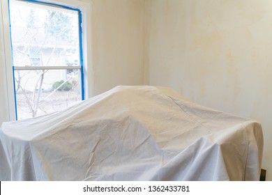 Furniture Covered With A Painting Tarp For Protection During Home Improvement Renovations. Walls Covered In Paint Primer