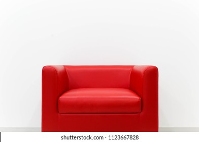 Furniture red sofa is located next to the white cement wall. - Shutterstock ID 1123667828