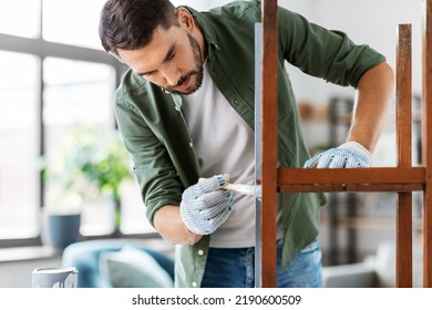 Furniture Renovation, Diy And Home Improvement Concept - Man In Gloves With Paint Brush Painting Old Wooden Table Or Chair In Grey Color