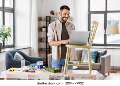 Furniture Restoration, Diy And Home Improvement Concept - Happy Smiling Man With Laptop Preparing Old Wooden Chair For Renovation