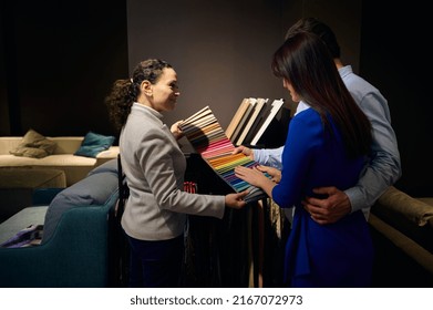 Furniture Store Female Sales Manager Holding Fabric Swatches For Furniture Upholstery. Interior Designer Giving Advice To Clients On New Home Design Project. Housing Projects, Interior Design Concept