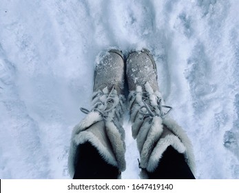 Furry White Snow Boots Standing On Fresh Snow.