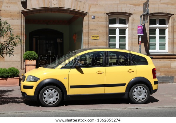 FURTH, GERMANY - MAY 6, 2018: Yellow Audi\
A2 compact mini car parked in Germany. The car was designed by\
Belgian car designer Luc\
Donckerwolke.