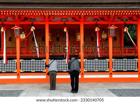 Fushimi Ward, Kyoto, Kansai Region, Japan, Asia - mature couple praying at Fushimi Inari-taisha Shrine, head shrine of Inari