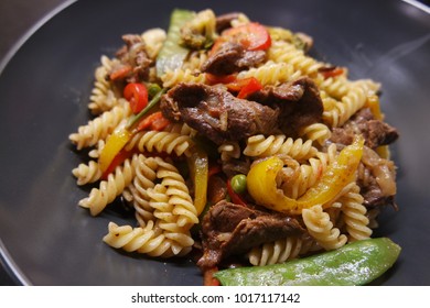 Fusilli With Vegtables And Sliced Beef On A Nice Black Plate