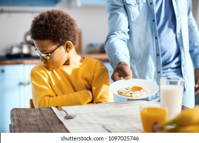 Fussy Eater. Pouting Pre-teen Boy Sitting At The Table And Turning Away While Refusing To Eat A Fried Egg