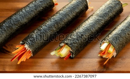 Futomaki sushi rolls. Whole vegan rolls with carrot, zucchini, celeriac, red pepper, kohlrabi.