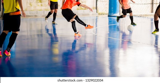 Futsal player  trap and control the ball for shoot to goal. Soccer players fighting each other by kicking the ball. Indoor soccer sports hall. Football futsal player, ball, futsal floor.
