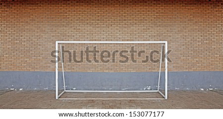 A futsal soccer goal post against a brickwall. 