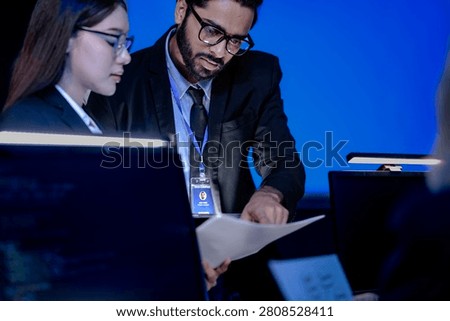 Future AI performance review human team analyzes model output metrics comparing AI generated charts tablet data verify ethical alignment autonomous system operations center night mode active.