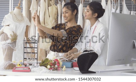 Future bride customer talking with wedding store shopkeeper to buy wedding dress and accessories for her upcoming wedding ceremony.