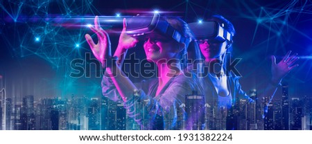 Future digital technology game and entertainment, Teenager having fun play VR virtual reality goggle, sport game 3D cyber space futuristic neon colorful smart city background, 