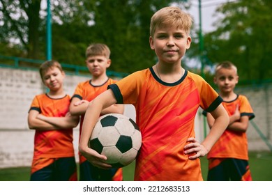 Future football champions. Little boys, kids in sports uniform posing with ball at soccer school stadium. Concept of sport, studying, achievements, success and skills. Looks happy, confident - Powered by Shutterstock