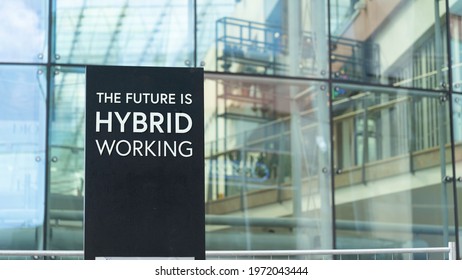 The Future Is Hybrid Working Sign In Front Of A Modern Office Building