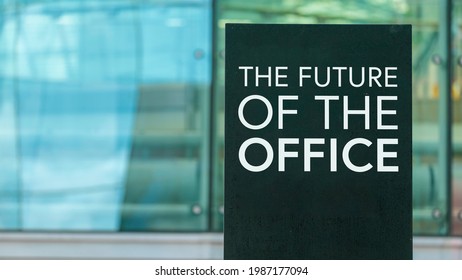 The Future of the office on a sign outside a modern glass office building	
