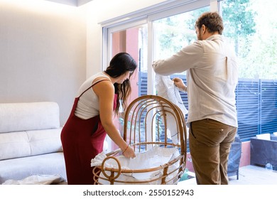 Future parents couple with pregnant woman preparing baby's crib on way at home - Powered by Shutterstock