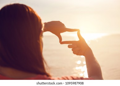 Future planning, Close up of woman hands making frame gesture with sunrise on sea summer, Female capturing the sunrise, sunlight outdoor. - Powered by Shutterstock