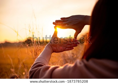 Future planning concept, Close up of woman hands making frame gesture with sunset, Female capturing the sunrise.