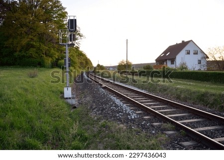 In the future, the railway tracks run between the forest and the house. In the foreground is an electric pole of the railway infrastructure