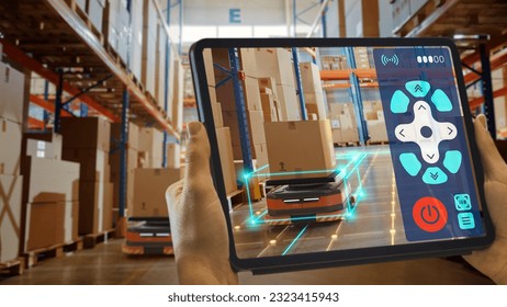 Future Technology Concept: Worker Holding Tablet With Remote Control AR Application For Automated Retail Warehouse AGV Robot with Infographics. Automated Guided Vehicles Delivering Goods, Products. - Powered by Shutterstock