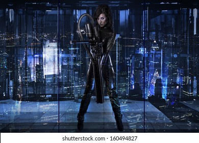 Future Woman Dressed In Black Latex With A Huge Gun In A Building At Night