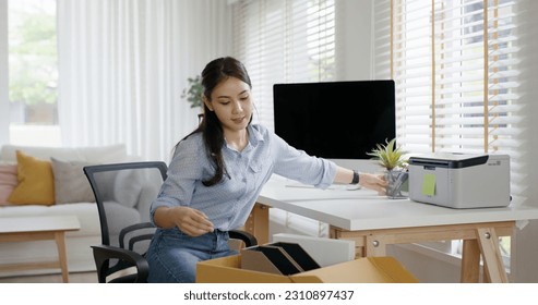 Future of workforce remote work fully permanent. Asia people happy relax move job to new small workspace set up desk picking file folder from box. Keep it chores neat start long term plan career work. - Shutterstock ID 2310897437