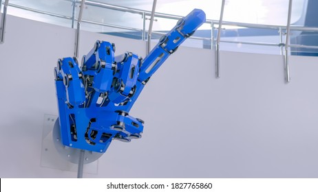 Futuristic Big Blue Mechanical Robotic Hand With Remote Control Moving Fingers And Showing Forefinger Pointing Gesture At Modern Robot Exhibition, Museum. Science, Future, Technology Concept