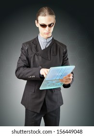 Futuristic Businessman Or Secret Agent Working On His High-tech Translucent Tablet.