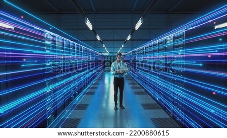 Futuristic Concept: Data Center Chief Technology Officer Holding Laptop, Standing In Warehouse, Information Digitalization Lines Streaming Through Servers. SAAS, Cloud Storage, Online Service