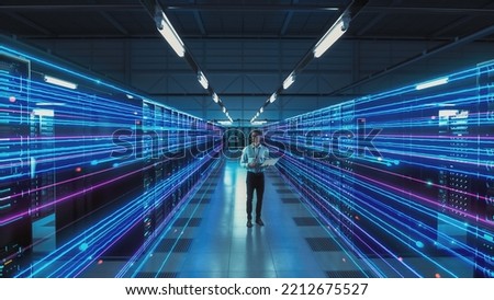 Futuristic Concept: Data Center Chief Technology Officer Using Laptop, Standing In Warehouse, Information Digitalization Lines Streaming Through Servers. SAAS, Cloud Storage, Online Service