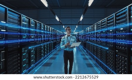 Futuristic Concept: Data Center Chief Technology Officer Holding Laptop, Standing In Warehouse, Information Digitalization Lines Streaming Through Servers. SAAS, Cloud Computing, Web Service