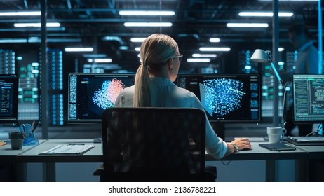 Futuristic Concept: Female Computer Engineer Looking on the Two Displays while Working on the Computer. Screen Shows Interactive Neural Network, Artificial Intelligence Project, User Interface