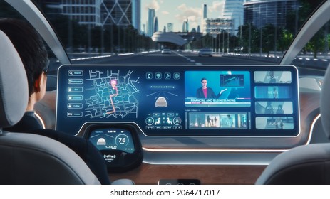 Futuristic Concept: Stylish Businessman Using Navigation App on an Augmented Reality Dashboard with Financial News Broadcast while Sitting in an Autonomous Self-Driving Zero-Emissions Electric Car.
