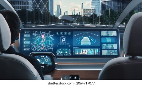 Futuristic Concept: Stylish Businessman Using Navigation App on an Augmented Reality Dashboard with Financial News Broadcast while Sitting in an Autonomous Self-Driving Zero-Emissions Electric Car.