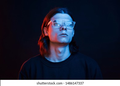 Futuristic Conception. Studio Shot In Dark Studio With Neon Light. Portrait Of Serious Man.