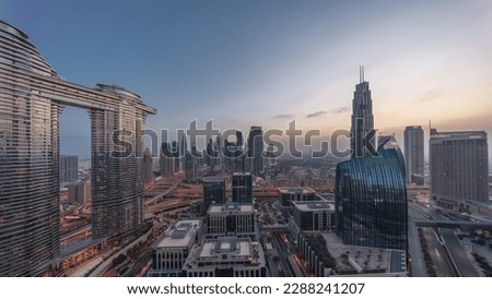 Futuristic Dubai Downtown and finansial district skyline aerial night to day transition . Many towers and skyscrapers with traffic on streets before sunrise