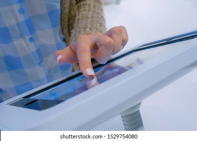 Futuristic, education, entertainment, learning, technology concept. Woman hand using touchscreen display of interactive floor standing white tablet kiosk at exhibition, museum, trade show - close up - Shutterstock ID 1529754080