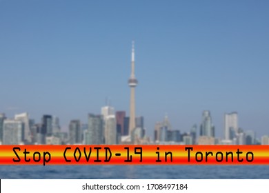 A Futuristic Font Stop Covid-19 Red Banner Over A Blurred Skyline Of Toronto