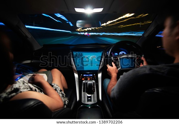 Futuristic interface of\
autonomous car. self driving vehicle. connected the internet of\
things. heads up display of a car driving at night through an\
illuminated on road